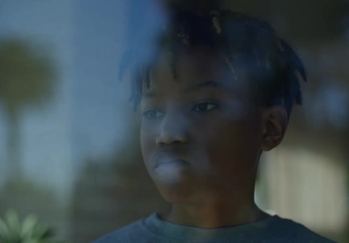 A boy is looking out the window