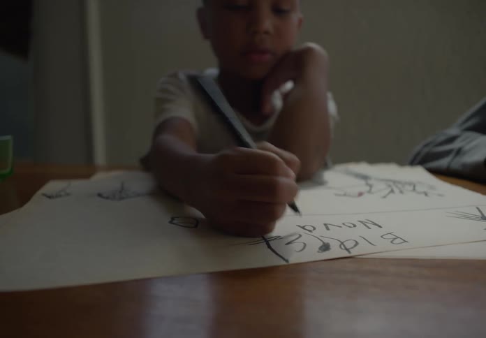 A child is writing on the paper