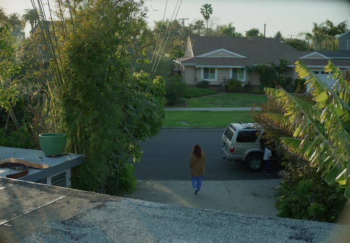 A woman talks to a man in her driveway while her sons get into his sport utility vehicle