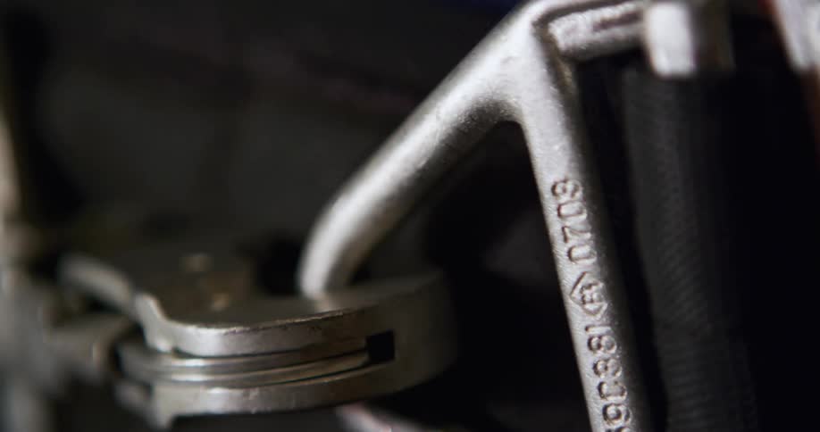 Extreme close up of a man hooking a strong metal buckle belt clip