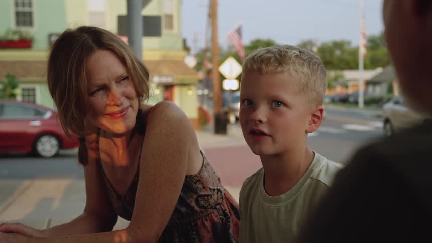 A boy is talking to his family on the corner