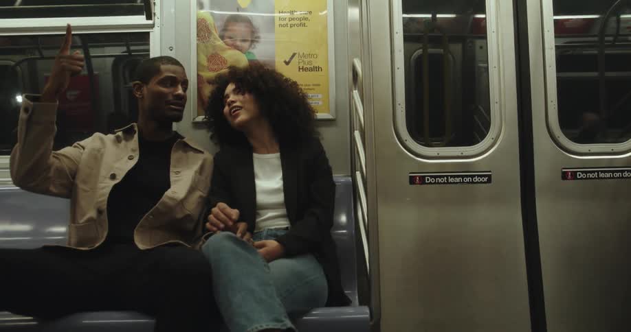 Young happy couple have a conversation while sitting on a metro car bench