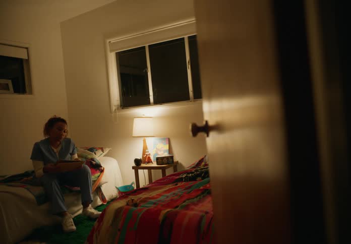 A woman is sitting on the bed reading a book