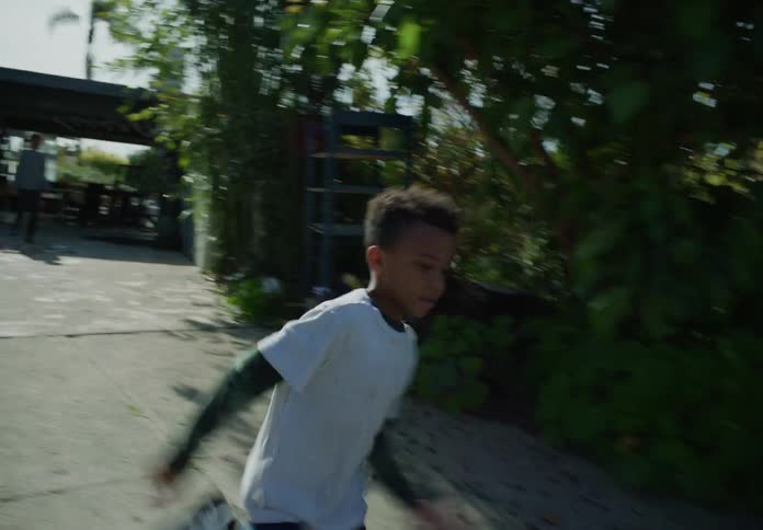 The kid chases the car along the parkway to the street