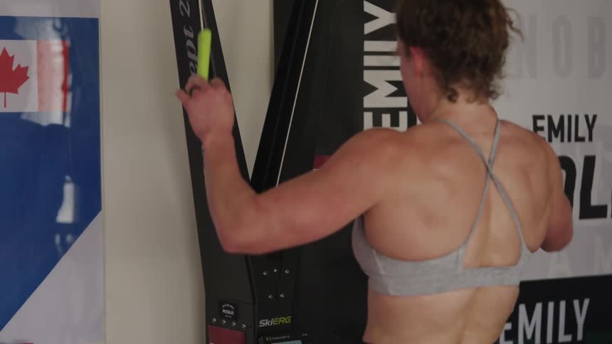 A woman using an exercise band pulling it down aggressively and then walking away