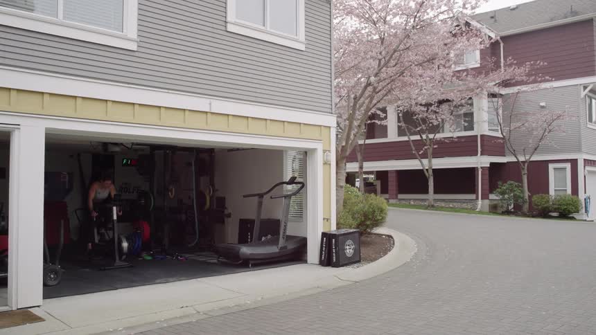A woman is riding a recumbent exercise bike in her garage
