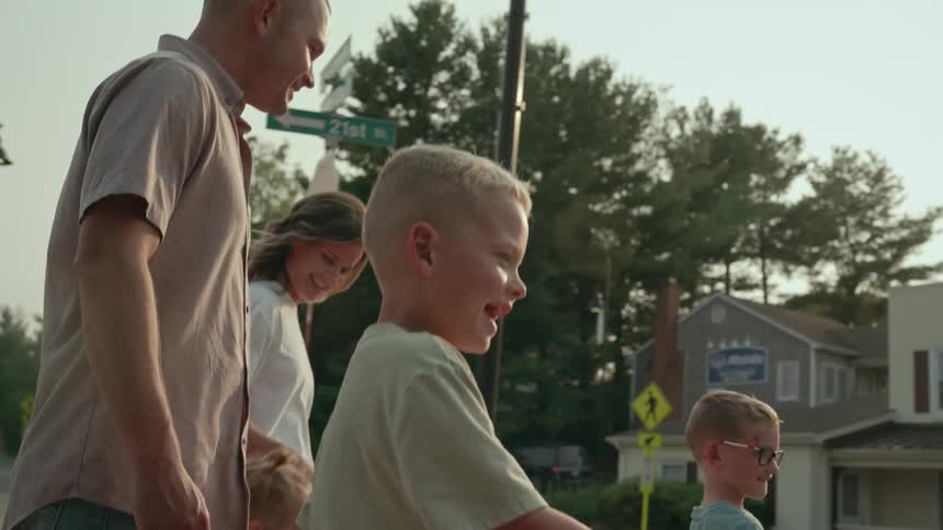 A family walks together through a neighborhood during the day