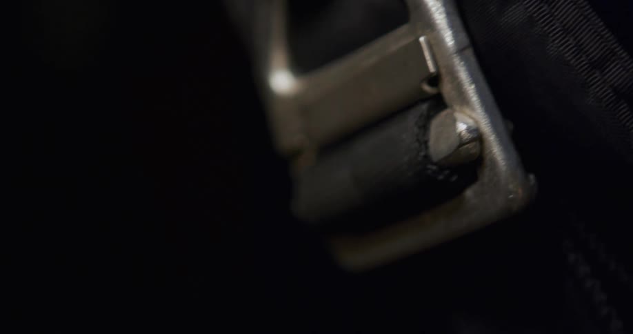 Metal buckle holds black strap on colorful fabric