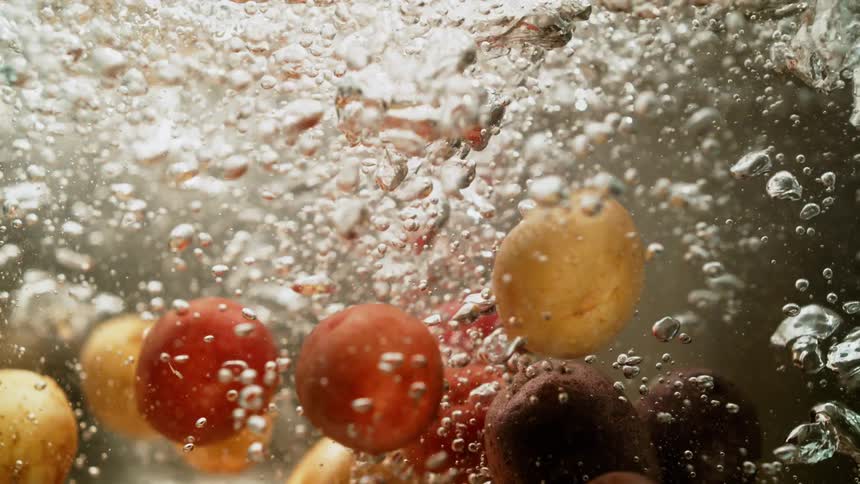 Potatoes being dropped into water showing bubbles