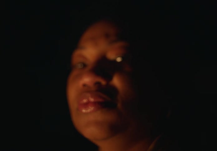 A close up of a womans face looking at the camera as it goes backward and the woman becomes blurry