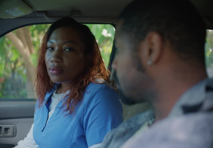 A woman nods and gets out of the car