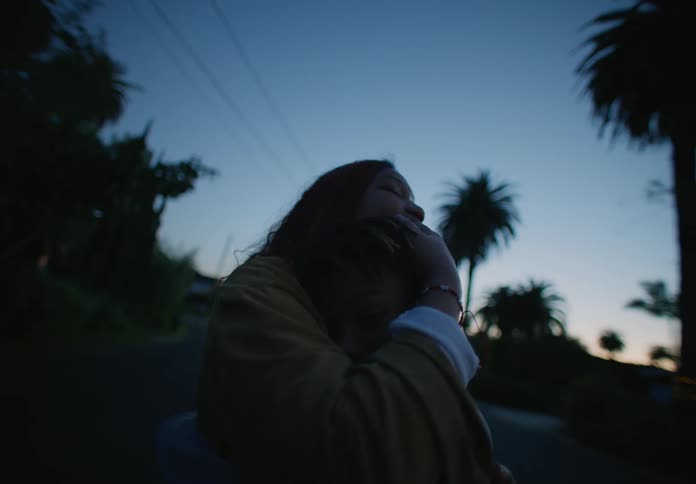 Mother waiting on the street hugs her son at evening