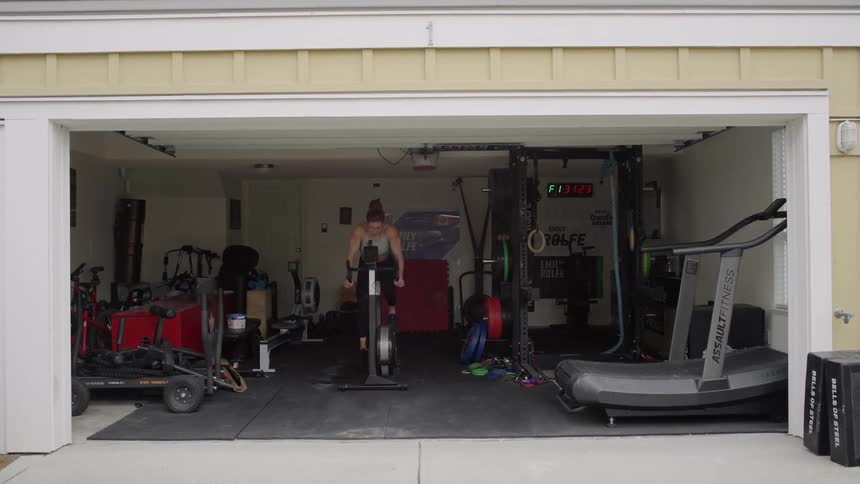 Woman pedals on stationary bicycle in garage home gym