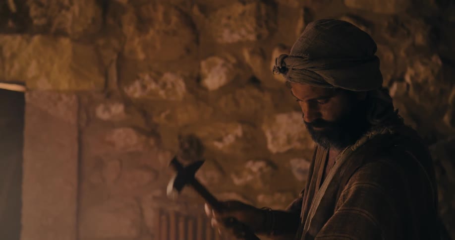 Traditional middle east stonemason carving a rock with hammer and chisel
