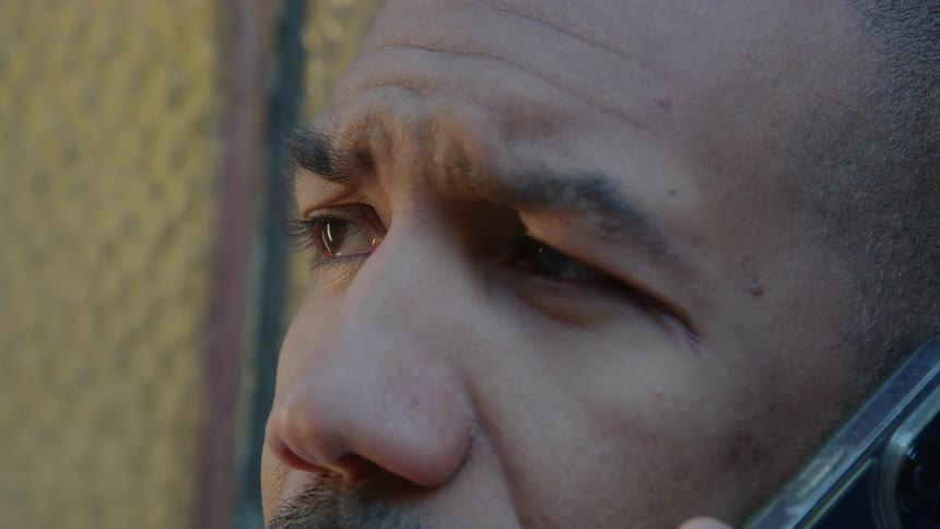 Close up of the frown in the forehead of a man talking on a smartphone
