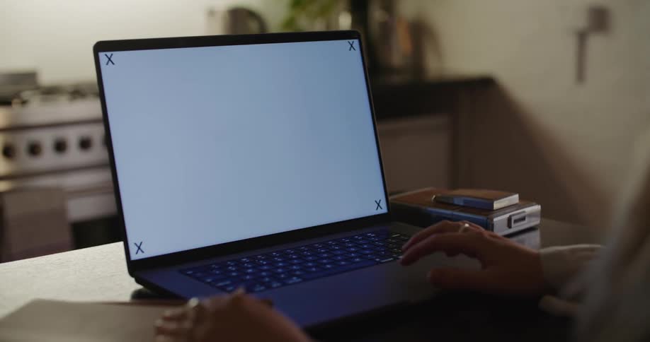 A close up of the side of a persons head as they use the laptop sitting in front of them