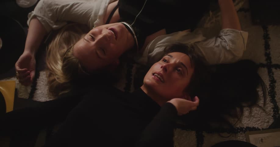 Close up of two friends laying on the apartment floor singing songs together