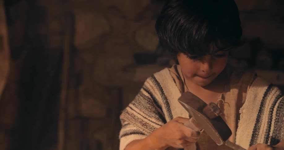Adult provides guidance as youth hammers chisel