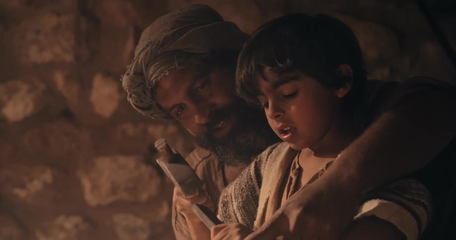 A father is teaching his son how to sculpt stone