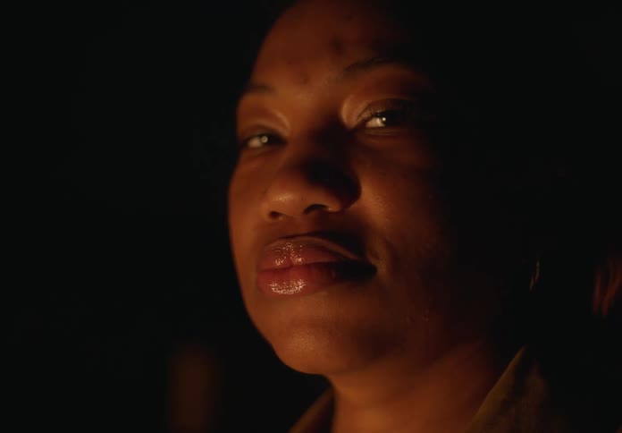 A woman is standing outdoors during the night time
