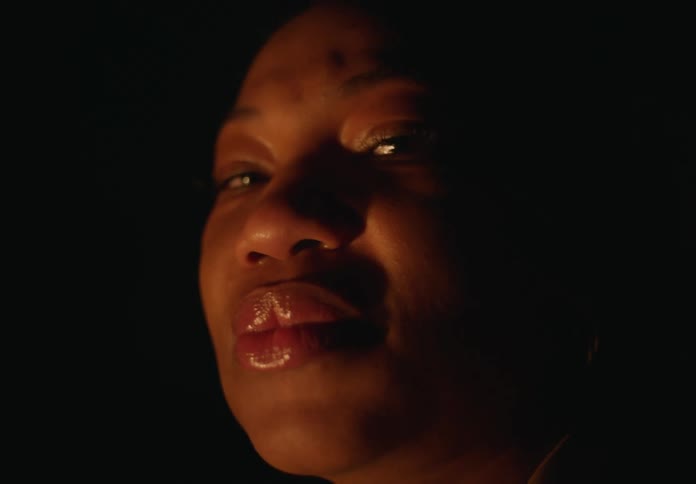 A woman is standing in the dark