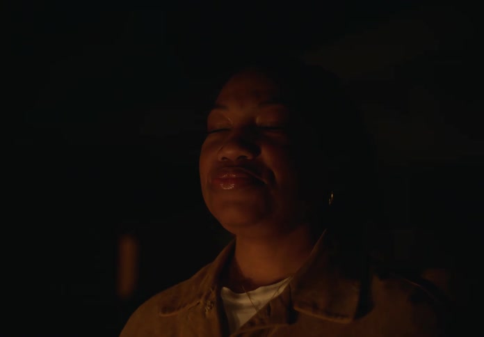 A woman outside with her eyes closed leaning her head back exposing her throat