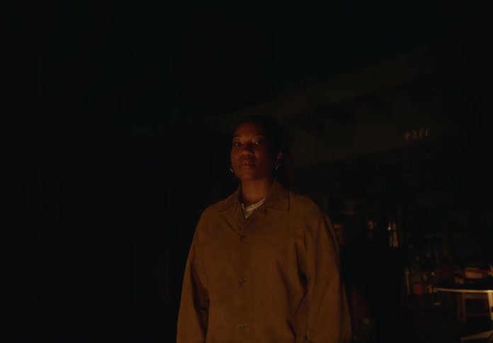 Woman standing inside a dark room during a blackout looking at the camera