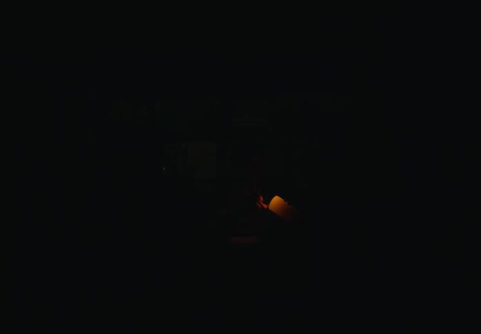 Family light candles in the dining room at home during a blackout at night