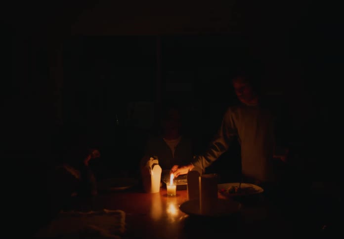 A child lights a candle in the dark
