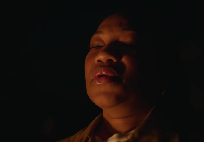 A close up of a womans face as she breathes in slowly while closing her eyes