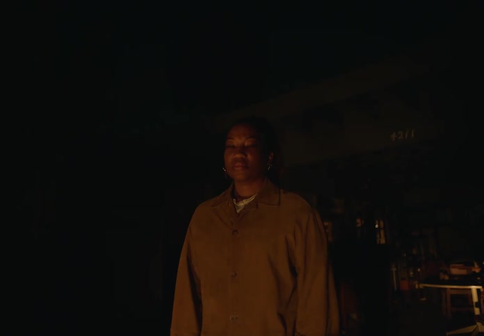 A woman standing outside at night looking at the camera