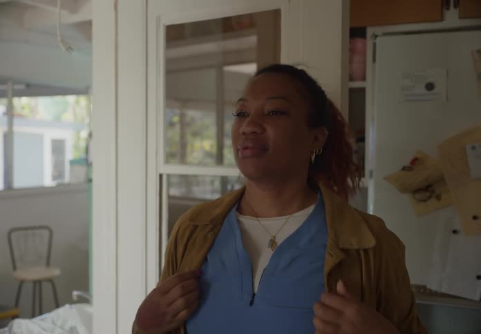 Woman opens door to kitchen and walks into room