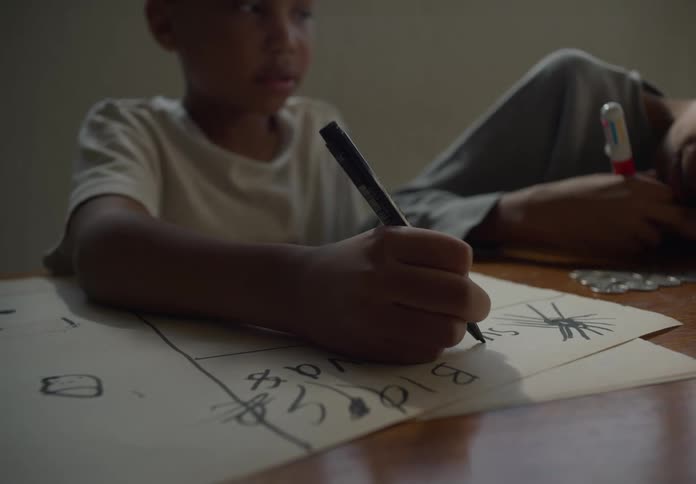 One brother writes on drawing as the other brother colors on small metal panel