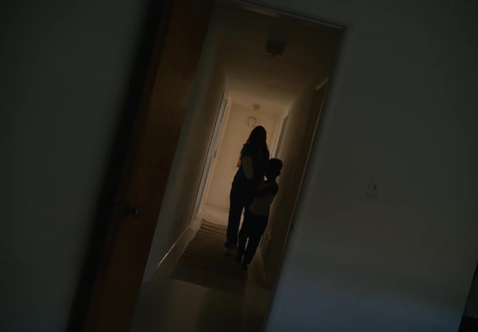 Son holds mothers hand and leads through corridor