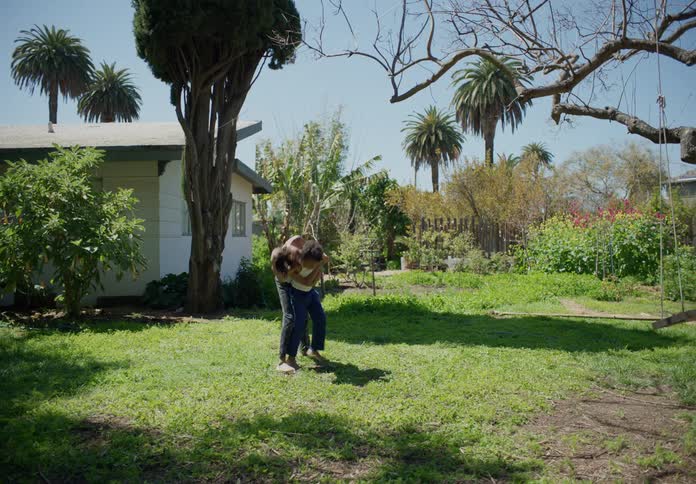 Two young boys wrestling having fun in the front yard on the lawn