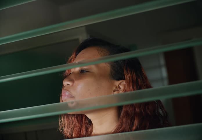Close up of the head of a woman opening a window to smell the aromas from the outside