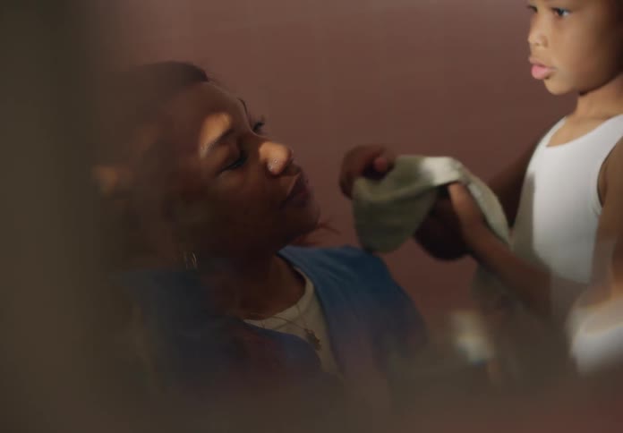 A boy dabs a womans forehead with a towel