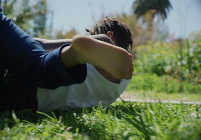 Brothers playing and wrestling around on the grass outside and getting up