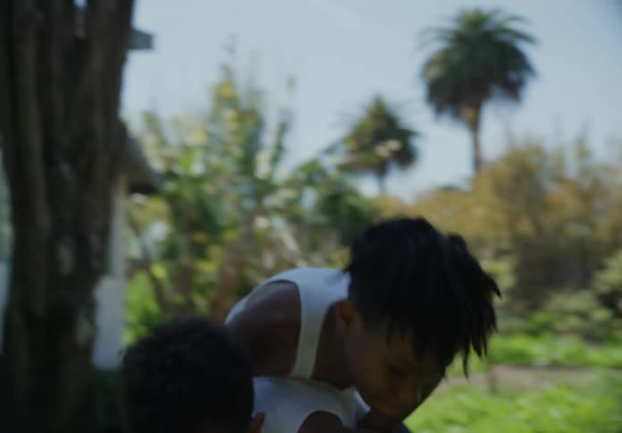 Two tween brothers playing in the front yard play wrestling
