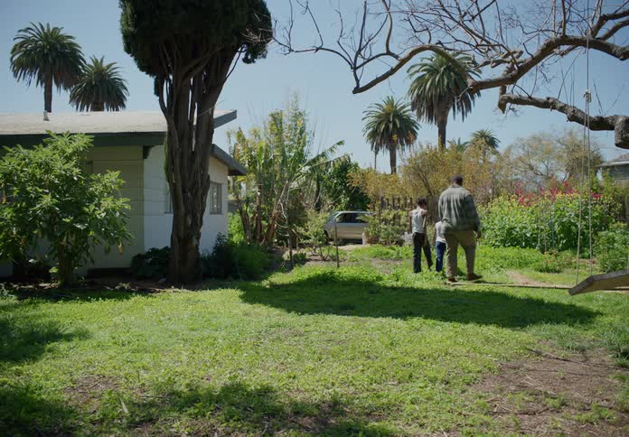Father waits for sons to get up from ground in yard and they walk to parked car