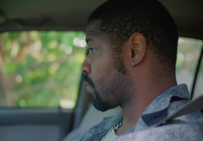 A man is sitting in the driver seat of an automobile looking around