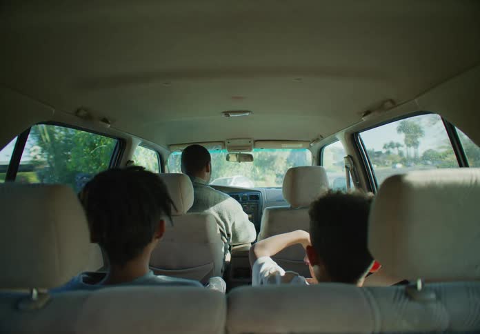 Father drives his children on the family car in the neighborhood at morning