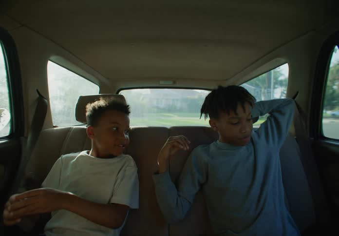 Two boys get cash from their parent before getting out of the car