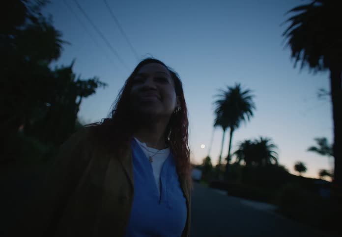 Close up of the face of a woman standing on a town street at evening