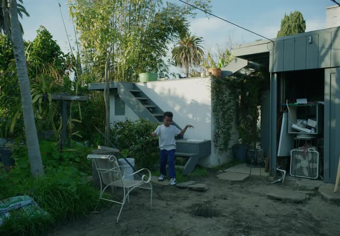 A child climbs into a hole in the yard