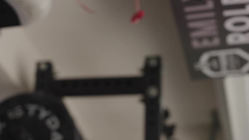 Close up of the face and arms of a strong muscular woman lifting weights over her head