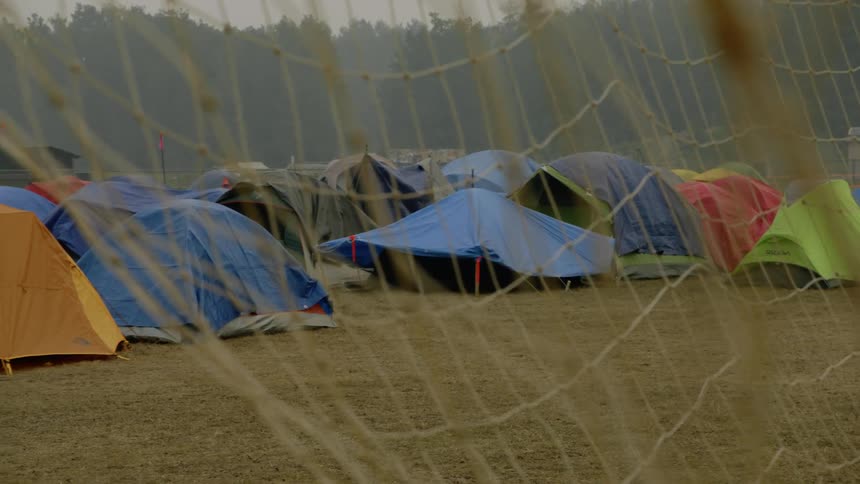A large group of tents are by the forest