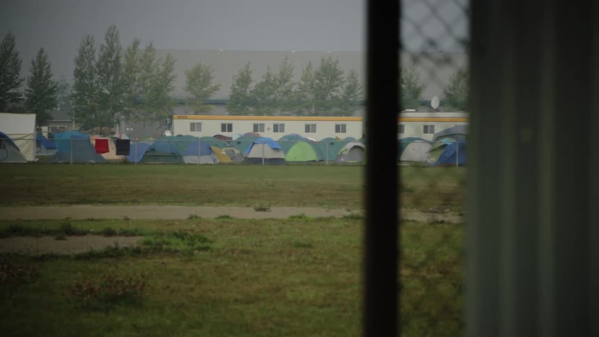 View of open field with several tents erected together as in a homeless community