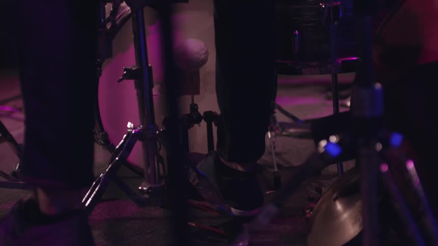A man is pressing the pedal on a drum