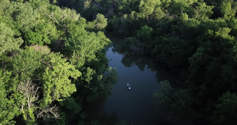 A canoe paddles in the water below